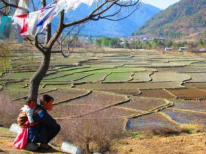 Woman with baby overlooking fields in Paro